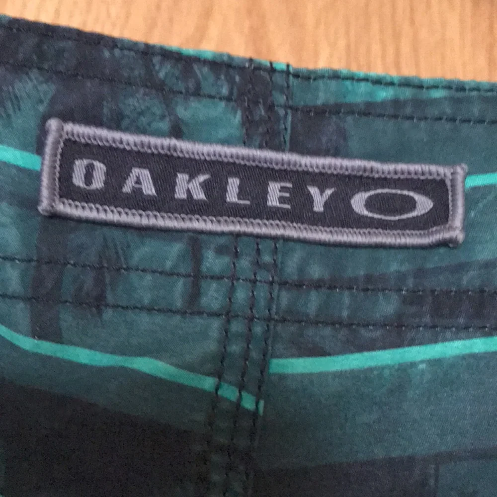 Oakley Origin size 30 x 10.5” black green striped board shorts swim trunks EUC